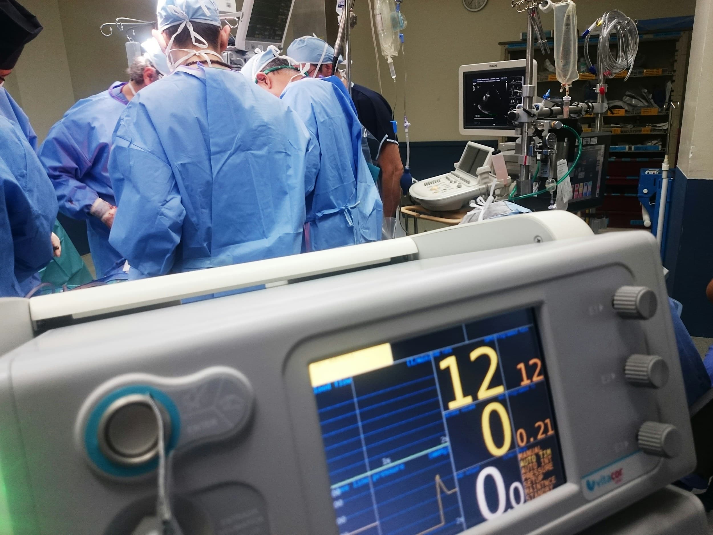 A clinical team working around patient-monitoring equipment in an operating room